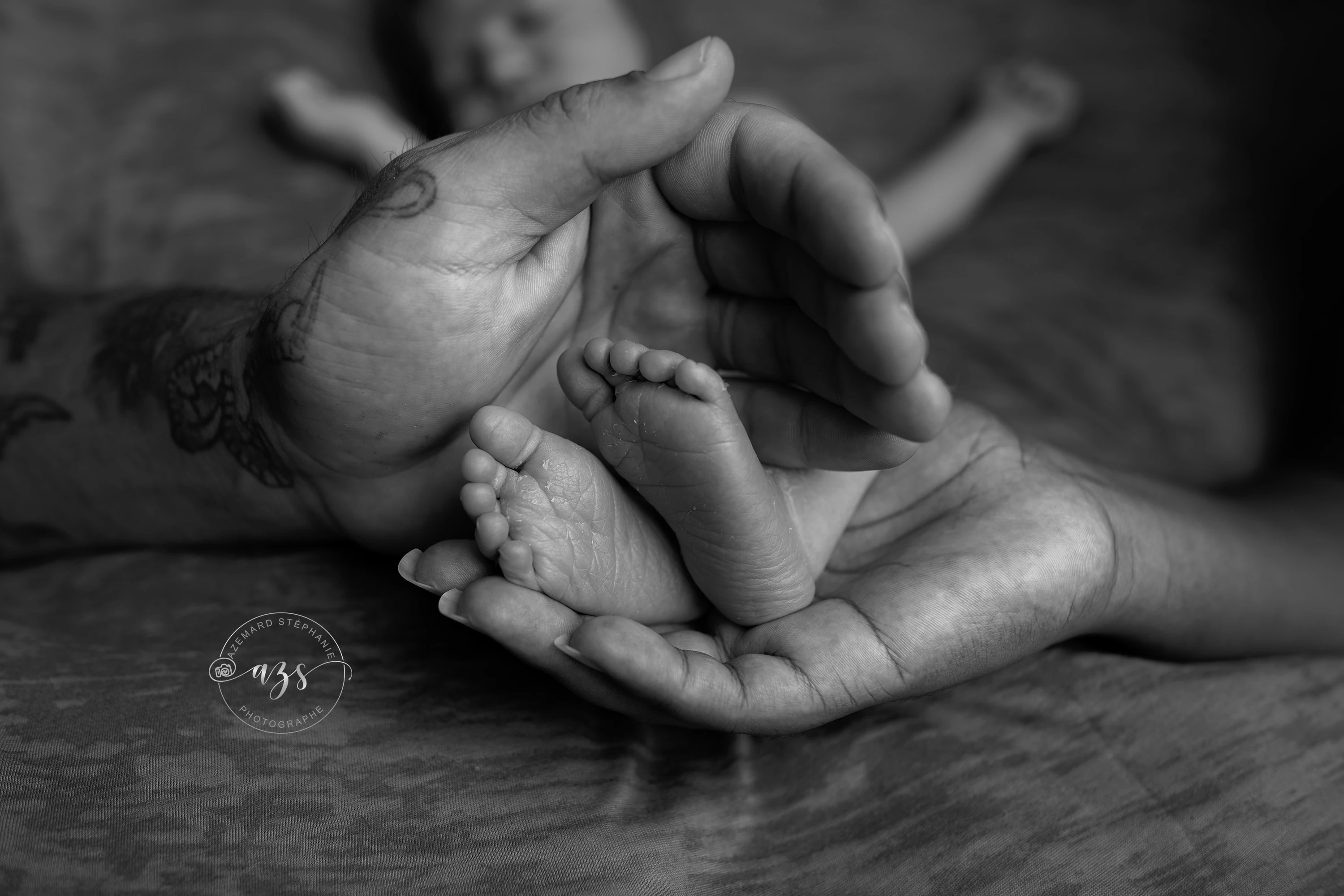Photo pieds de bébé nouveau-né dans les mains des parents en noir et blanc, photographe maternité Montpellier Stéphanie Azémard